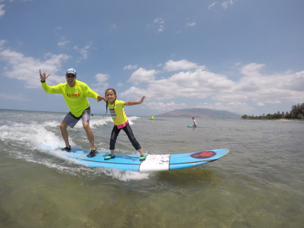 father and daughter surfing on Maui