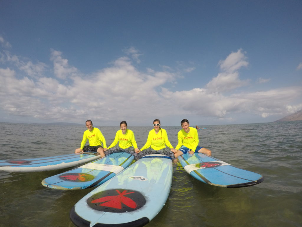 family on surf boards in the water in Kihei, HI